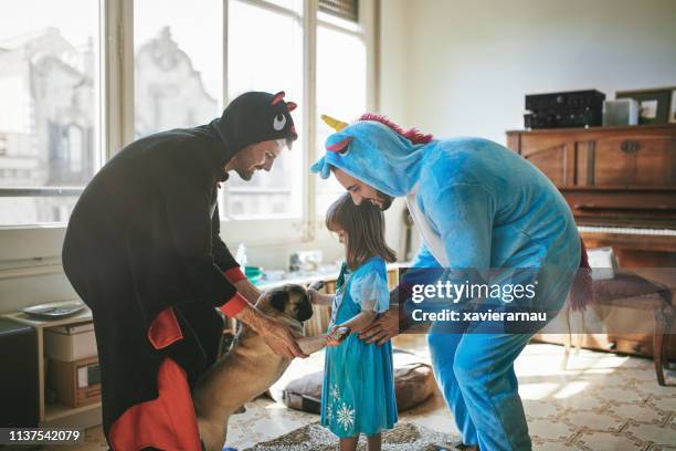 gay couple in costumes dancing with child and pug - pug unicorn stock pictures, royalty-free photos & images