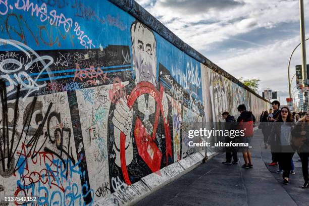 graffiti-gemälde an der east side gallery wand von berlin - east side gallery stock-fotos und bilder