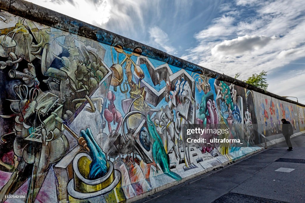 Pinturas dos grafittis na parede da galeria do leste lateral de Berlim Alemanha