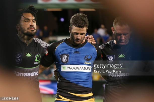 Digby Ioane and Andy Ellis of the World XV stand with Ian Prior of the Force stand with team mates to observe a moments silence to pay respect to the...