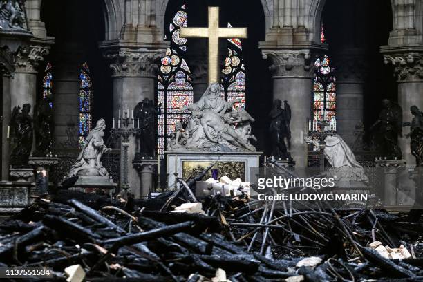 Picture taken on April 16, 2019 shows the altar surrounded by charred debris inside the Notre-Dame Cathedral in Paris in the aftermath of a fire that...