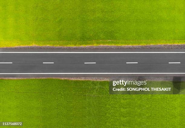 the road in the middle of the field./aerial shot - looking down the road stock pictures, royalty-free photos & images