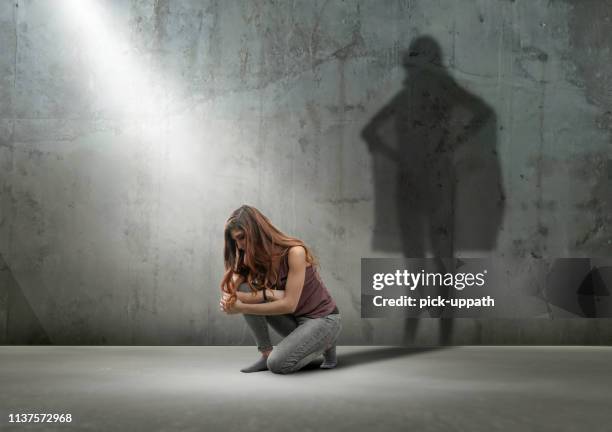 mujer agachándose con la sombra como super héroe - super hero shadow fotografías e imágenes de stock