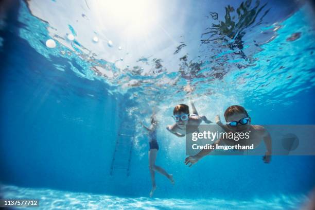 kids swimming underwater in pool - lido stock pictures, royalty-free photos & images