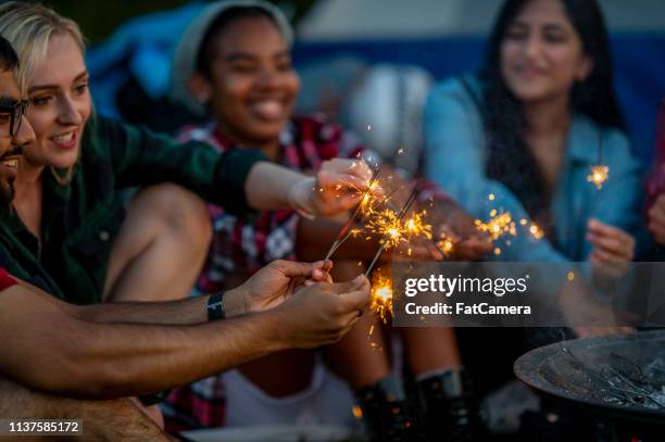 lighting sparklers - friends with sparkler fireworks stock pictures, royalty-free photos & images