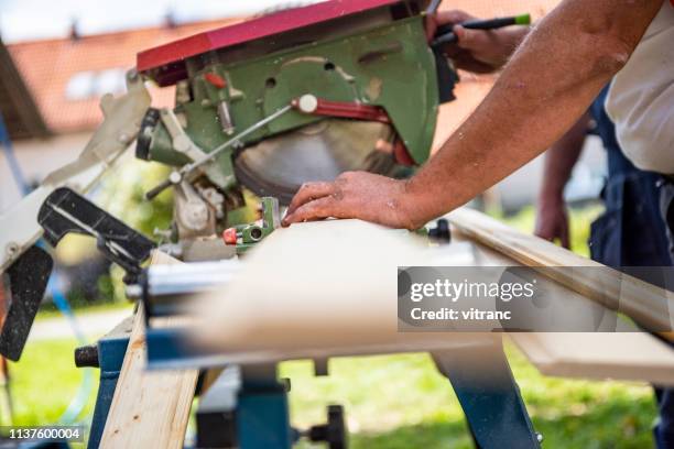 manual worker using circular saw while working at construction site - sawing stock pictures, royalty-free photos & images