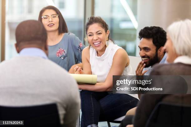 young businesswoman laughs with colleagues during meeting - indian community stock pictures, royalty-free photos & images