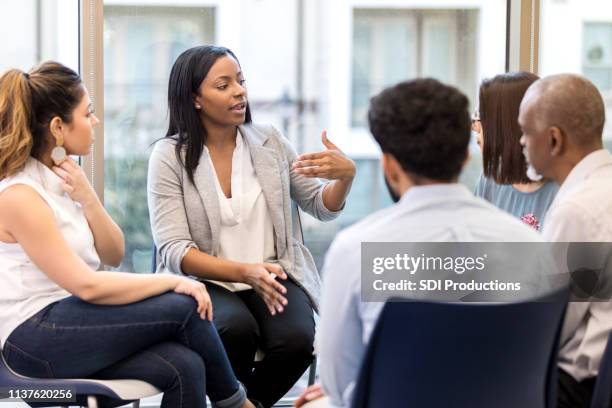 counselor speaks candidly during group session - serious discussion stock pictures, royalty-free photos & images