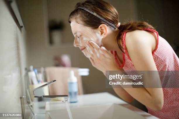 teenage girl washing her face - acnes stock pictures, royalty-free photos & images