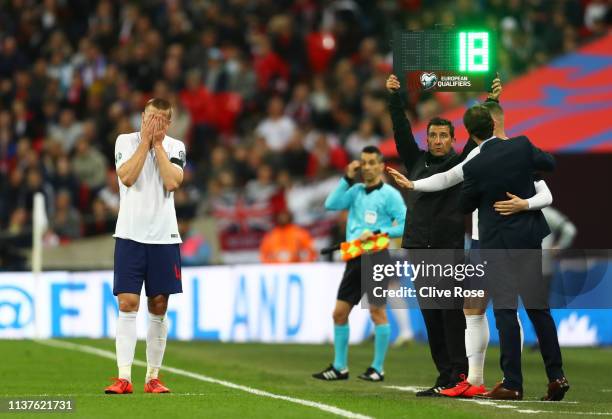 An injured Eric Dier of England reacts as Gareth Southgate manager of England and substitute Ross Barkley look on from the touchline during the 2020...