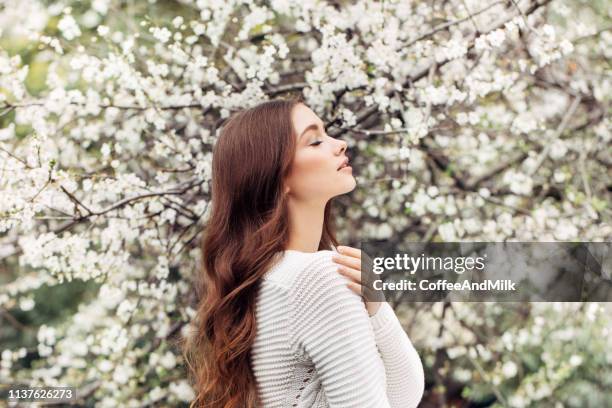 mooi meisje op de achtergrond van de lente bush - female bush photos stockfoto's en -beelden