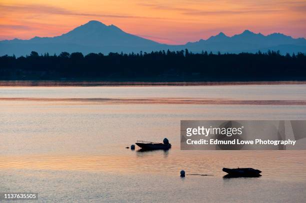 boats anchored in the salish sea at sunrise with mt. baker in the background. - mt baker stockfoto's en -beelden