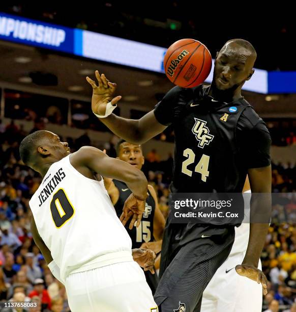 Tacko Fall of the UCF Knights battles for the ball with De'Riante Jenkins of the Virginia Commonwealth Rams in the first half during the first round...