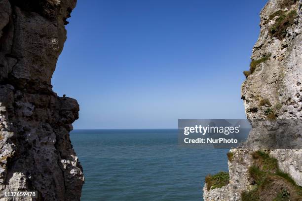 Etretat, Normandy, France, March 25, 2019. The cliff of Aval in good weather. An underground river, followed by marine erosion, formed a natural arch...