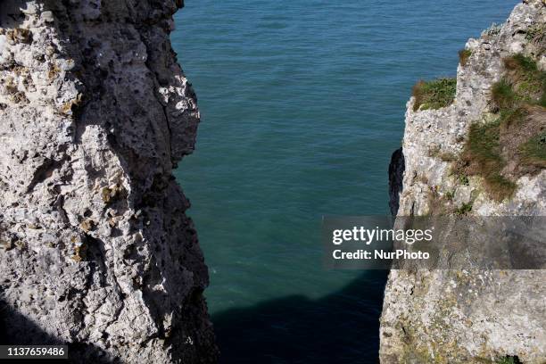 Etretat, Normandy, France, March 25, 2019. The cliff of Aval in good weather. An underground river, followed by marine erosion, formed a natural arch...