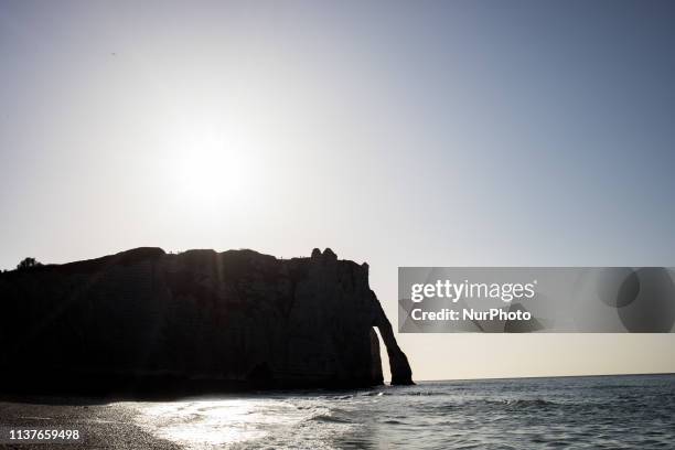 Etretat, Normandy, France, March 25, 2019. The cliff of Aval in good weather. An underground river, followed by marine erosion, formed a natural arch...