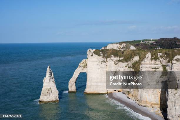 Etretat, Normandy, France, March 25, 2019. The cliff of Aval in good weather. An underground river, followed by marine erosion, formed a natural arch...