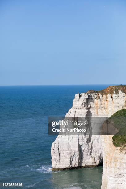 Etretat, Normandy, France, March 25, 2019. The cliff of Aval in good weather. An underground river, followed by marine erosion, formed a natural arch...