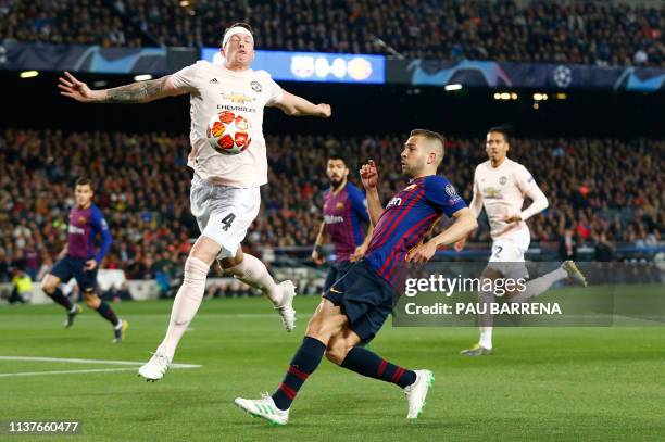 Barcelona's Spanish defender Jordi Alba challenges Manchester United's English defender Phil Jones during the UEFA Champions League quarter-final...