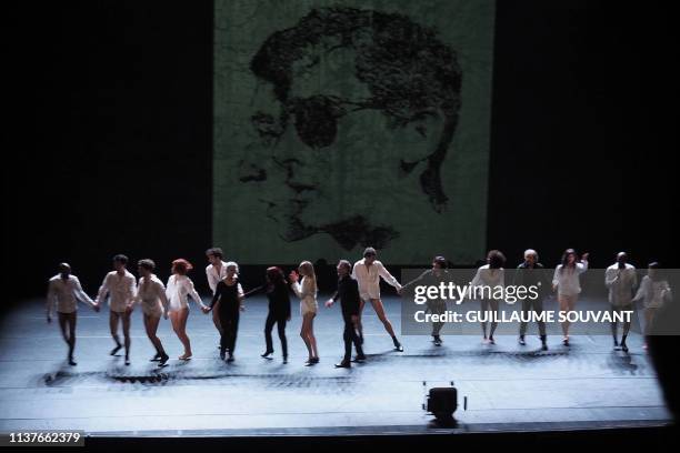 Dancers perform in front of a giant poster depicting late French singers Serge Gainsbourg and Alain Bashung during the premiere of "L'Homme a tete de...