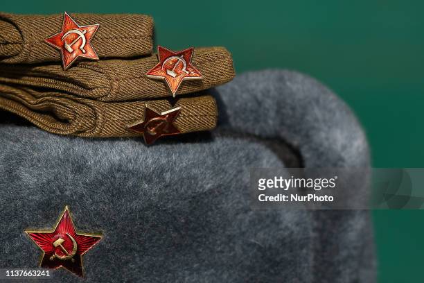Stand with a Russian WW2 military hat pilotka and Winter Army Hat Ushanka, both with Soviet Red Star badge, seen on display in a street market...