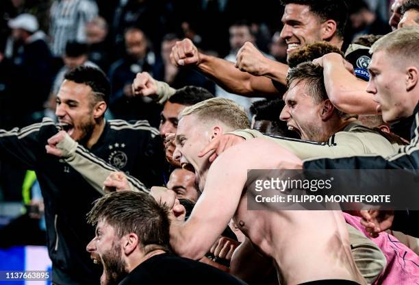Ajax's Dutch midfielder Donny van de Beek and teammates celebrate defeating Juventus at the end of the UEFA Champions League quarter-final second leg...
