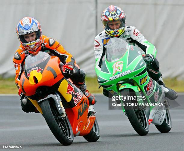 125cc class world champion Arnaud Vincent of France is chased by San Marino rider Alex de Angelis during the qualifying practice session for the...