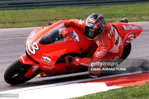 Italian MotoGP rider Max Biaggi leans his Marlboro Yamaha into a corner of the Sepang International Circuit during the first practice session of the...