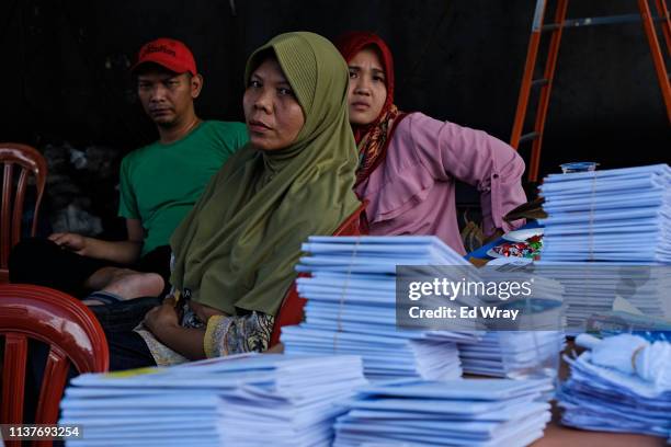 Indonesians wait to vote next to a pile of empty ballots discuss at a polling station on on April 17, 2019 in Cibinong, Indonesia.