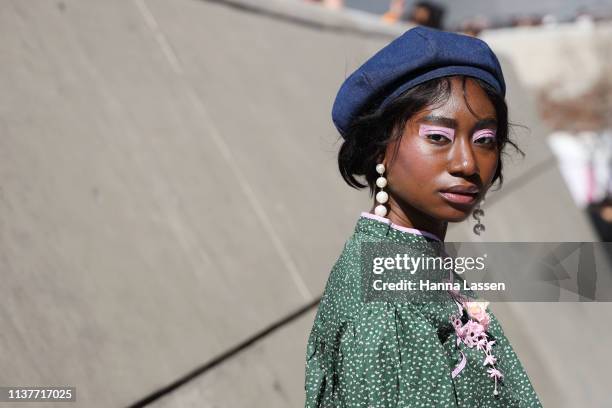Guest wearing blue denim beret, green shirt and pink eye shadow is seen at the Hera Seoul Fashion Week 2019 F/W at Dongdaemun Design Plaza at...