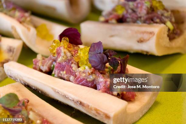 carpaccio with marrow and olive oil pearls on bone - carpaccio alimento fotografías e imágenes de stock
