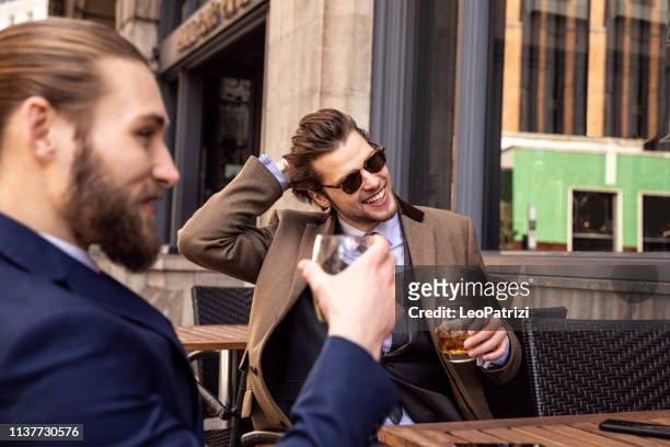 business break - two young businessmen taking a break in central london - whiskey stock pictures, royalty-free photos & images