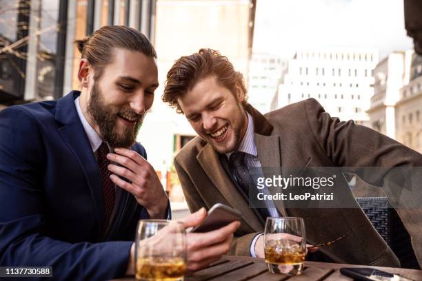business break - two young businessmen taking a break in central london - whisky a go go stock pictures, royalty-free photos & images