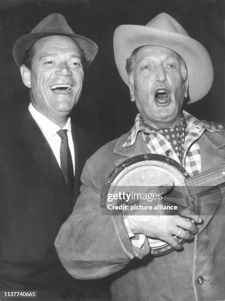 Der Schauspieler Eddie Constantine und sein deutscher Kollege Hans Albers singen am 19.9.1958 in Hamburg zu den Klängen eines Banjos ein Cowboy-Lied....