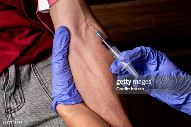 paramedic injects a patient in the arm - antibiotic injection stock pictures, royalty-free photos & images