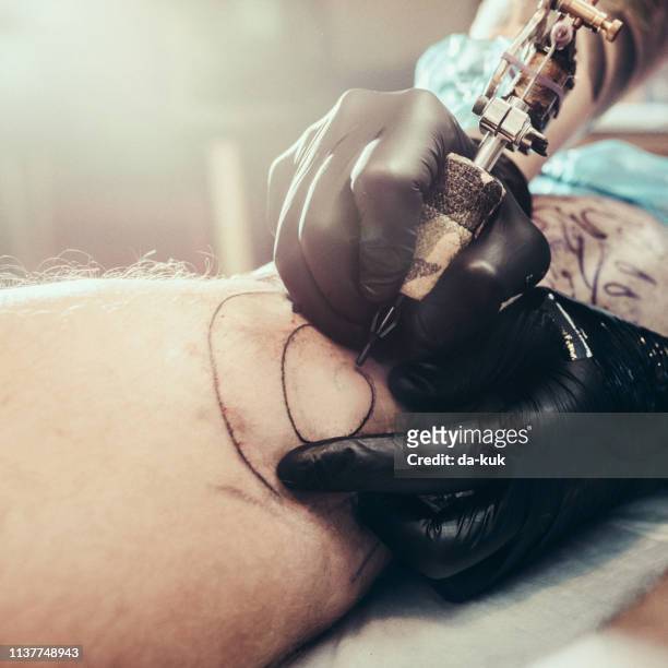 tattoo master making tattoo on leg - sewing needle stock pictures, royalty-free photos & images
