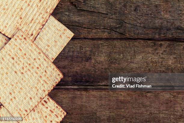 four pieces of matzah or matza on a vintage wood background with copy space or text space - コーシャー ストックフォトと画像