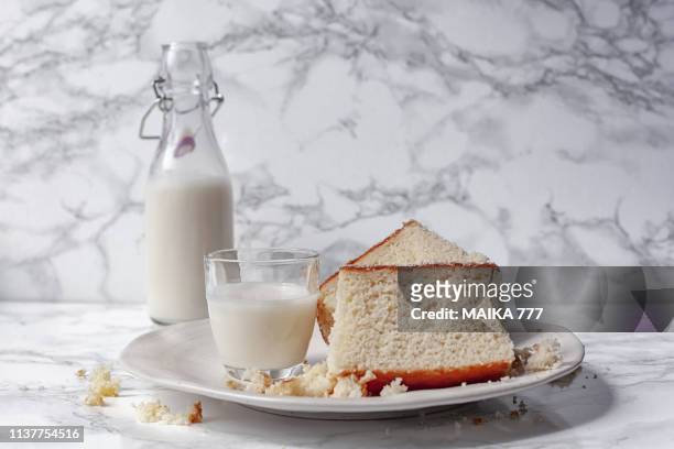 slices of home made coconut loaf cake and nut milk in a flip-top bottle - cake stockfoto's en -beelden