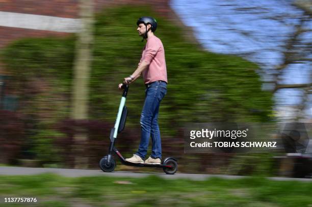 Man rides an E-Scooter of rental company Tier in Berlin on April 17, 2019. - German ministers agreed rules for using battery-powered scooters on the...