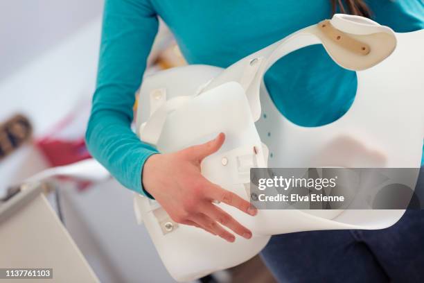 midsection of teenager carrying a back brace used for scoliosis correction - sezione centrale foto e immagini stock