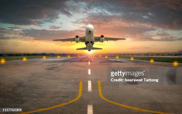 airplane taking off from the airport runway in beautiful sunset light - business air travel photos et images de collection