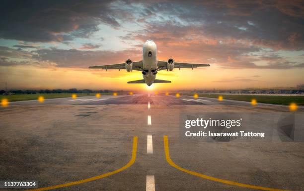 airplane taking off from the airport runway in beautiful sunset light - plane take off stockfoto's en -beelden