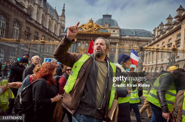 Gilets Jaunes or Yellow Vest protestors demonstrating and chant against President Macron and his government in front of the Palais de Justice during...