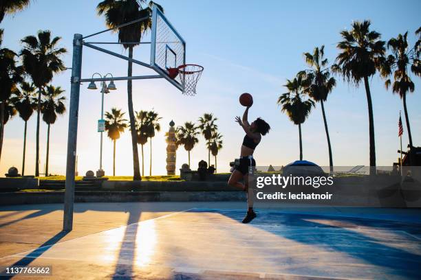 basket-ball de pratique de jeune femme à venise, californie - los angeles photos et images de collection