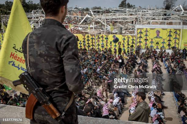 Syrian Democratic Forces fighter watches over guests attending the SDF victory ceremony announcing the defeat of ISIL in Baghouz held at Omer Oil...