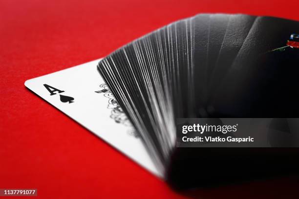 playing cards, ace of spades and deck on red surface - dealing cards stock pictures, royalty-free photos & images