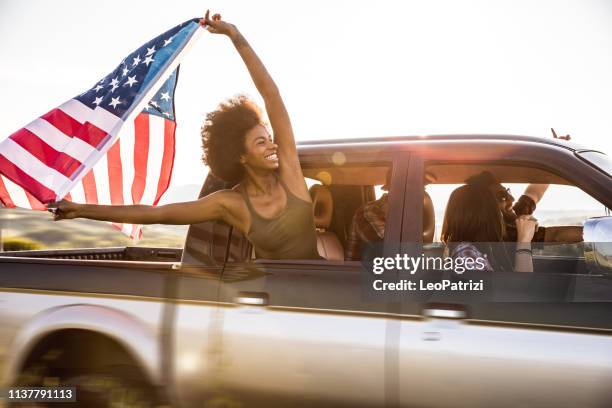 young and fresh group of friends enjoying a road trip journey and freedom in a country road - american flag jpg stock pictures, royalty-free photos & images