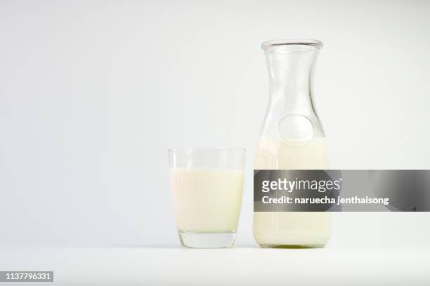 soy milk in a glass and a bottle on a white background - sojamilch stock-fotos und bilder