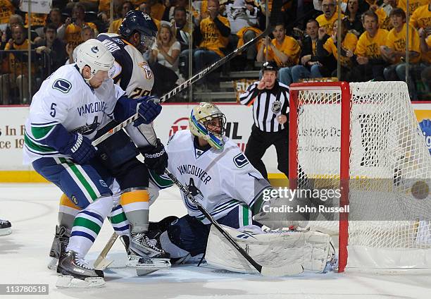 Joel Ward of the Nashville Predators gets the puck in the net against Roberto Luongo of the Vancouver Canucks as Christian Ehrhoff defends in Game...