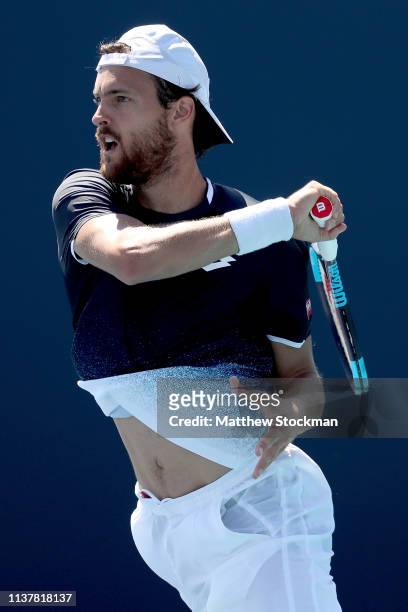 Joao Sousa of Portugal returns a shot to Steve Johnson during the Miami Open Presented by Itau at Hard Rock Stadium March 23, 2019 in Miami Gardens,...